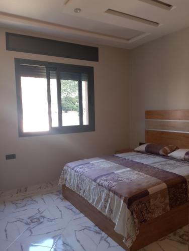a bedroom with two beds and a window at Appartement Wad Marsa in Taoutiet el Bioute