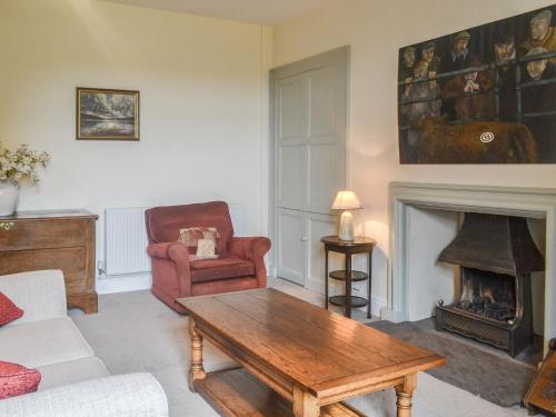 a living room with a coffee table and a fireplace at East Monkton Farm Cottage in Wick