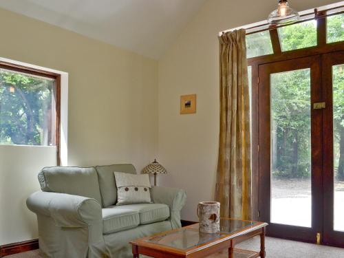 a living room with a couch and a table at Waterfall Cottage in Tansley