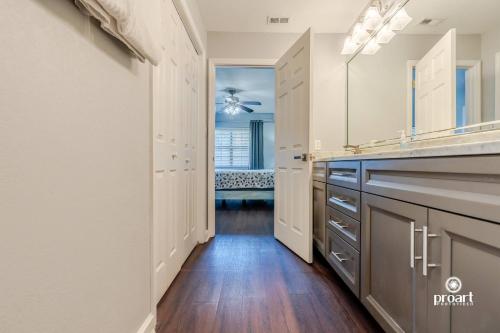 a kitchen with wood floors and a long hallway at Vitamin Sea 0.6 miles to beach, monthly disc in Destin
