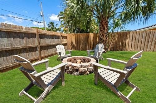three chairs and a fire pit in a yard at Brand New Pool Coming Golf Beach Dining Retr in Jupiter
