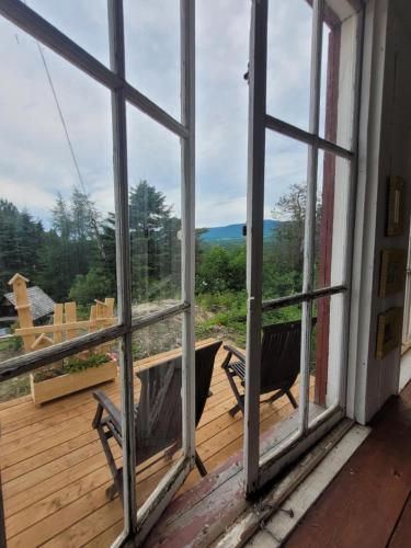 a view from the porch of a house with windows at Gîte champêtre Chesham in Notre-Dame-Des-Bois