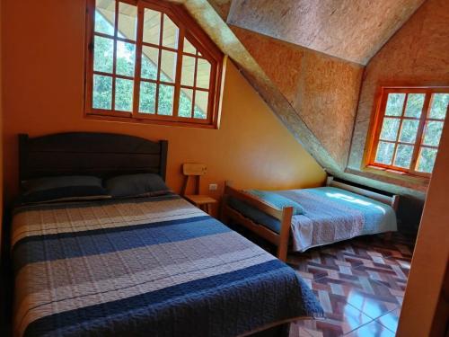 a bedroom with two beds and two windows at Hospedaje Mariana oxapampa in Oxapampa