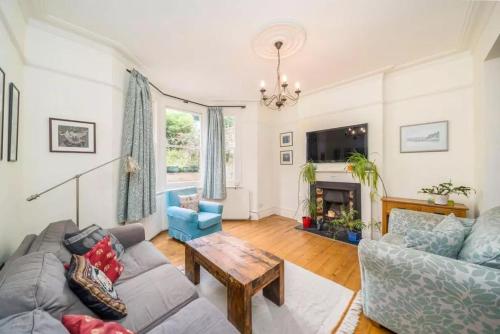 a living room with a couch and a table at EEJs Luxe 5 Bed Home - Greenwich in London