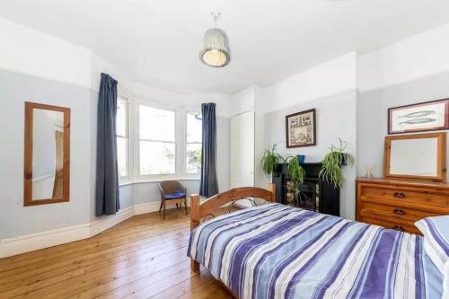 a bedroom with a bed and a dresser and a mirror at EEJs Luxe 5 Bed Home - Greenwich in London