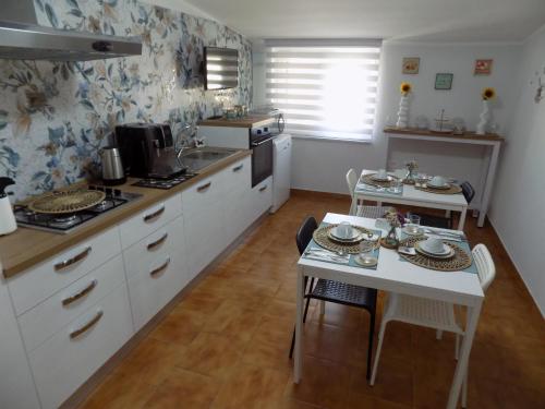 a kitchen with white cabinets and a table and a sink at Torre Serena B&B in Atella