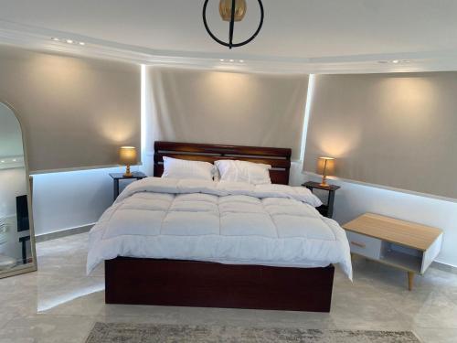 a bedroom with a large bed and two night stands at Pyramids Top Roof in Ghaţāţī