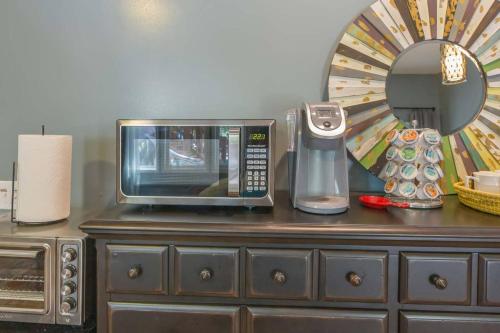 a microwave sitting on top of a wooden dresser at Poolside boho chic studio - dog friendly! in Wake Forest