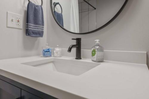 a white bathroom sink with a mirror above it at Poolside boho chic studio - dog friendly! in Wake Forest