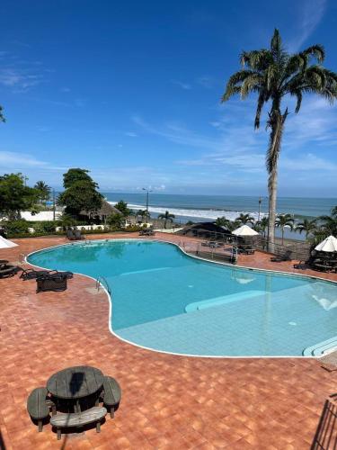a large swimming pool with a view of the ocean at Penthouse frente al mar in Tonsupa