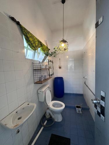 une salle de bain avec toilettes, lavabo et fenêtre dans l'établissement Cozy Loft Bed Mini Studio Golf View, à Gua Sai