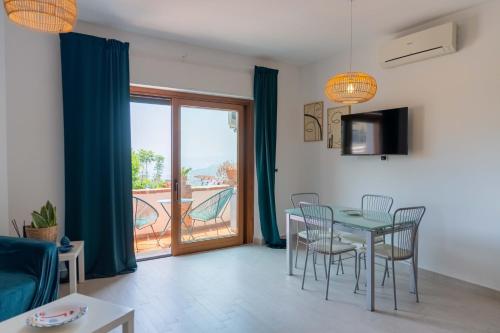 a dining room with a table and chairs and a balcony at A Me Casa - Taormina in Taormina