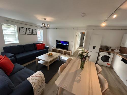 a living room with a blue couch and a table at Modern Stay - Walk to Everything 4 in Ipswich