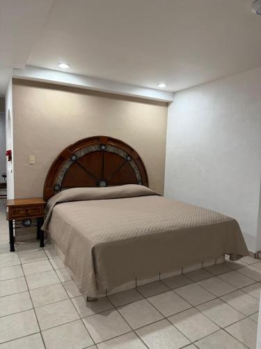a bedroom with a large bed with a wooden headboard at Casa Olas in Puerto Vallarta