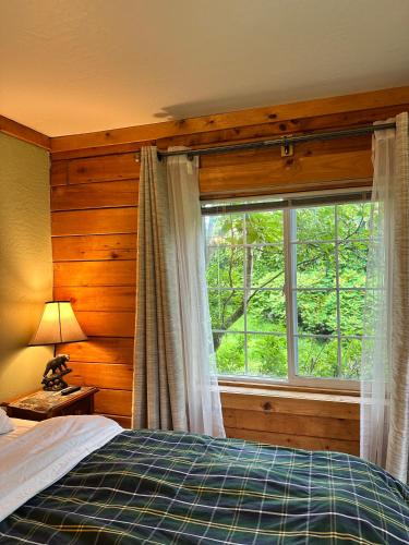 ein Schlafzimmer mit einem Bett und einem großen Fenster in der Unterkunft Homer Floatplane Lodge in Homer