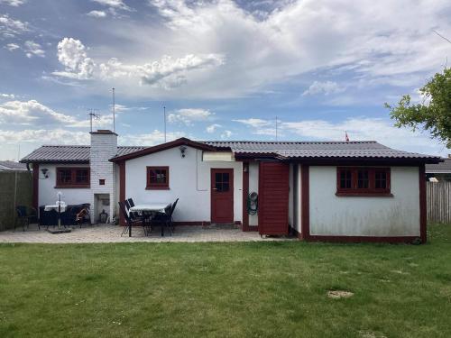 a small white house with a table in a yard at 6 person holiday home in Løgstør in Løgstør