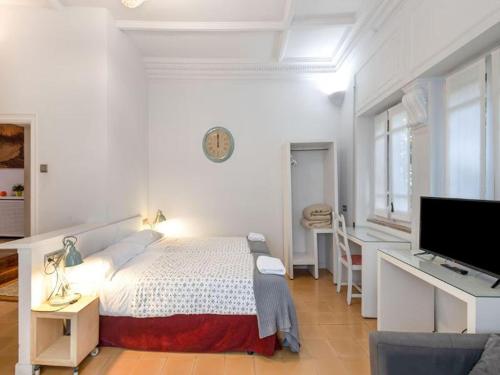 una camera da letto bianca con un letto e una TV a schermo piatto di Farmhouse in Anoia near Montserrat Monastery a Capellades