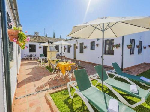 a patio with a table and chairs and an umbrella at Studio in Spain with Private Pool and Garden in Rivero de Posadas