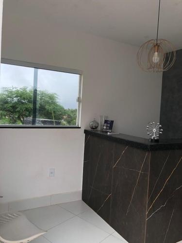 a white room with a counter and a window at Villa Chalés in Piranhas