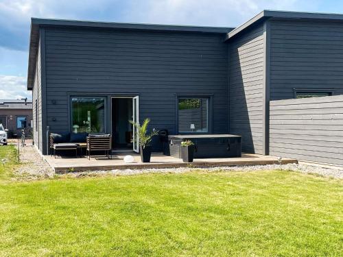 a black house with a patio and a lawn at 5 star holiday home in MÖRBYLÅNGA in Mörbylånga