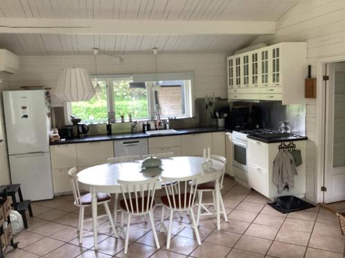 a kitchen with a white table and chairs in it at 5 person holiday home in Nakskov in Nakskov