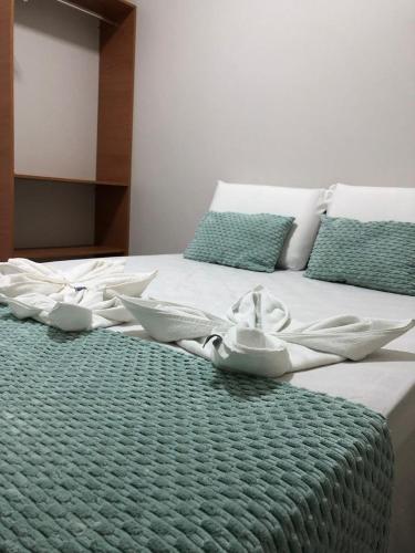 a bed with white sheets and bowls on it at Villa Chalés in Piranhas