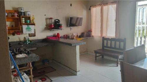 a kitchen with a counter and a bench in a room at Hospedaria lençóis em santo amaro MA in Santo Amaro