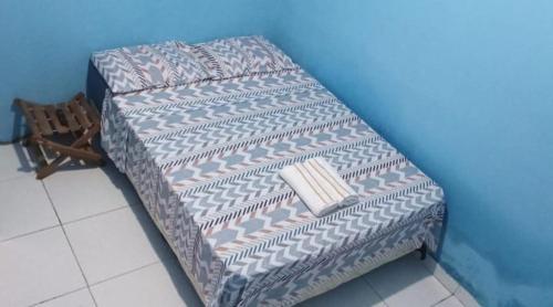 a couch against a blue wall with a book on it at Hospedaria lençóis em santo amaro MA in Santo Amaro