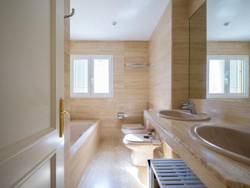 a bathroom with two sinks and two toilets at Chalet in Maspalomas by Golf & Private Pool in Maspalomas