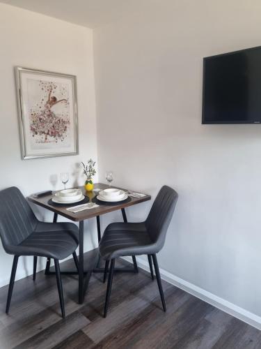 a dining room table with two chairs and a television at Cozy Studio Newly Furnished in Colchester