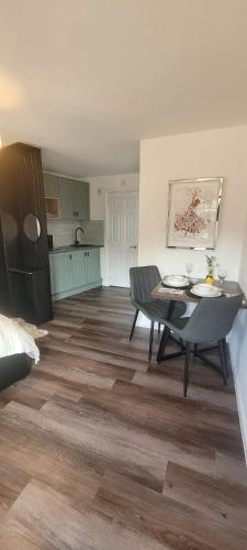 a living room with a table and a kitchen at Cozy Studio Newly Furnished in Colchester