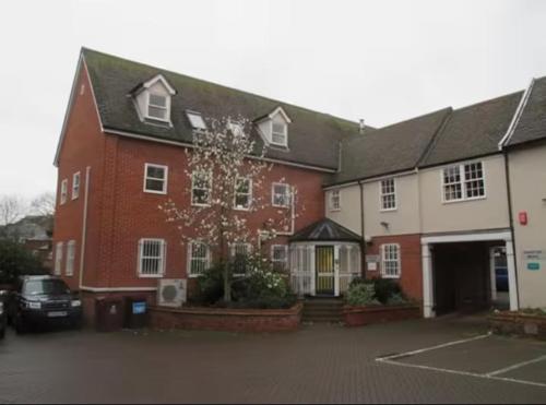 a large red and white building with a parking lot at Modern Stay - Walk to Everything 2 in Ipswich