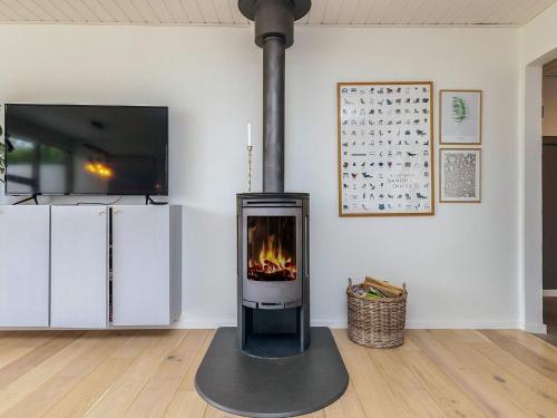 a fireplace sitting in a living room with a tv at 4 star holiday home in Ålbæk in Ålbæk