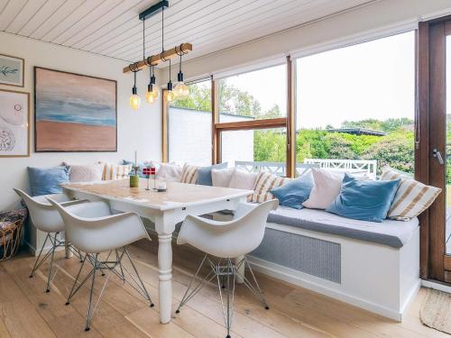 a dining room with a couch and a table at 4 star holiday home in Ålbæk in Ålbæk
