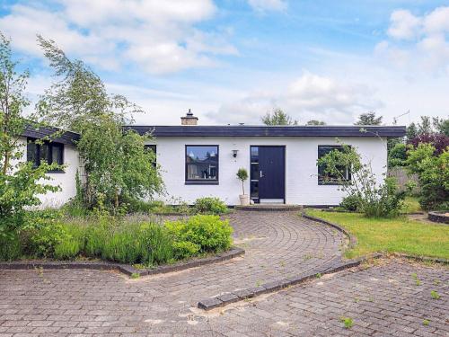 a white house with a driveway in front of it at 4 star holiday home in Ålbæk in Ålbæk