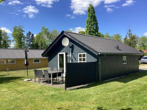 a black shed with a table in a yard at 6 person holiday home in Hovborg in Hovborg