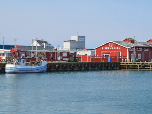a boat docked next to a marina with buildings at 5 star holiday home in Thyborøn in Thyborøn