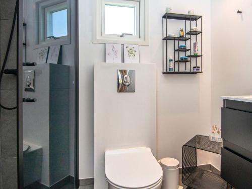 a bathroom with a toilet and a window at 4 star holiday home in Juelsminde in Sønderby