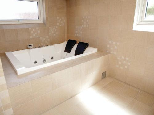 a white bath tub in a bathroom with a window at 5 star holiday home in Thyborøn in Thyborøn