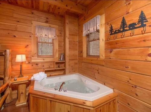 een badkamer met een bad in een blokhut bij Stunning views!Petfriendly22 with Pool table, Free tickets to Dollywood,Anakeesta,Aquarium &more in Sevierville