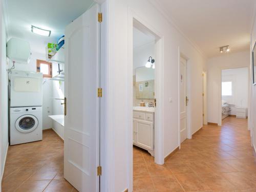 - une buanderie blanche avec lave-linge et sèche-linge dans l'établissement Apartment in Tufia with Oceanfront Terrace, à Telde