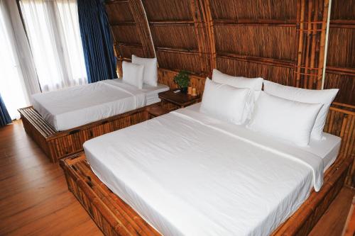 a bedroom with two beds with white pillows at Cat Ba Holiday Retreat in Cat Ba
