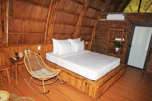 a bedroom with a bed and a chair in a room at Cat Ba Holiday Retreat in Cat Ba