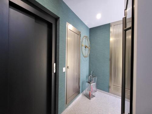 Un baño con paredes azules y una puerta con un reloj. en House in Telde near Playa de Melenara, en Telde