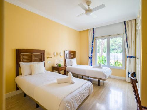 two beds in a room with yellow walls at Chalet in Maspalomas by Golf & Private Pool in Maspalomas