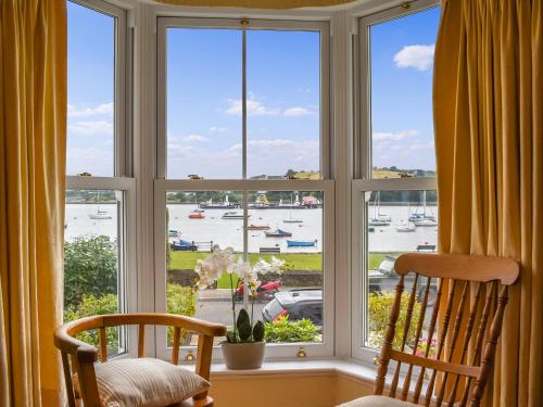 una finestra con due sedie e vista sul porto di Waterside Cottage a Saltash