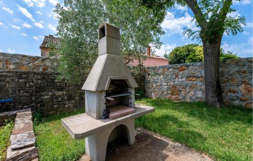 a stone oven in a yard next to a stone wall at 1 Bedroom Awesome Home In Bale in Krmed