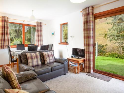 una sala de estar con un sofá y una mesa en Bidean Cottage - Uk41933, en Glencoe