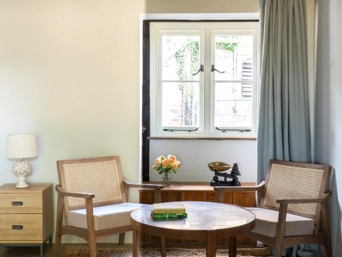 a living room with two chairs and a table and a window at Blackrock Barn in Clifford
