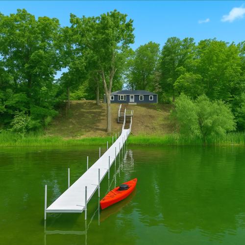 a red kayak sitting next to a dock on a lake at New! Private Lakefront Retreat 3BR 2BA Game Room 